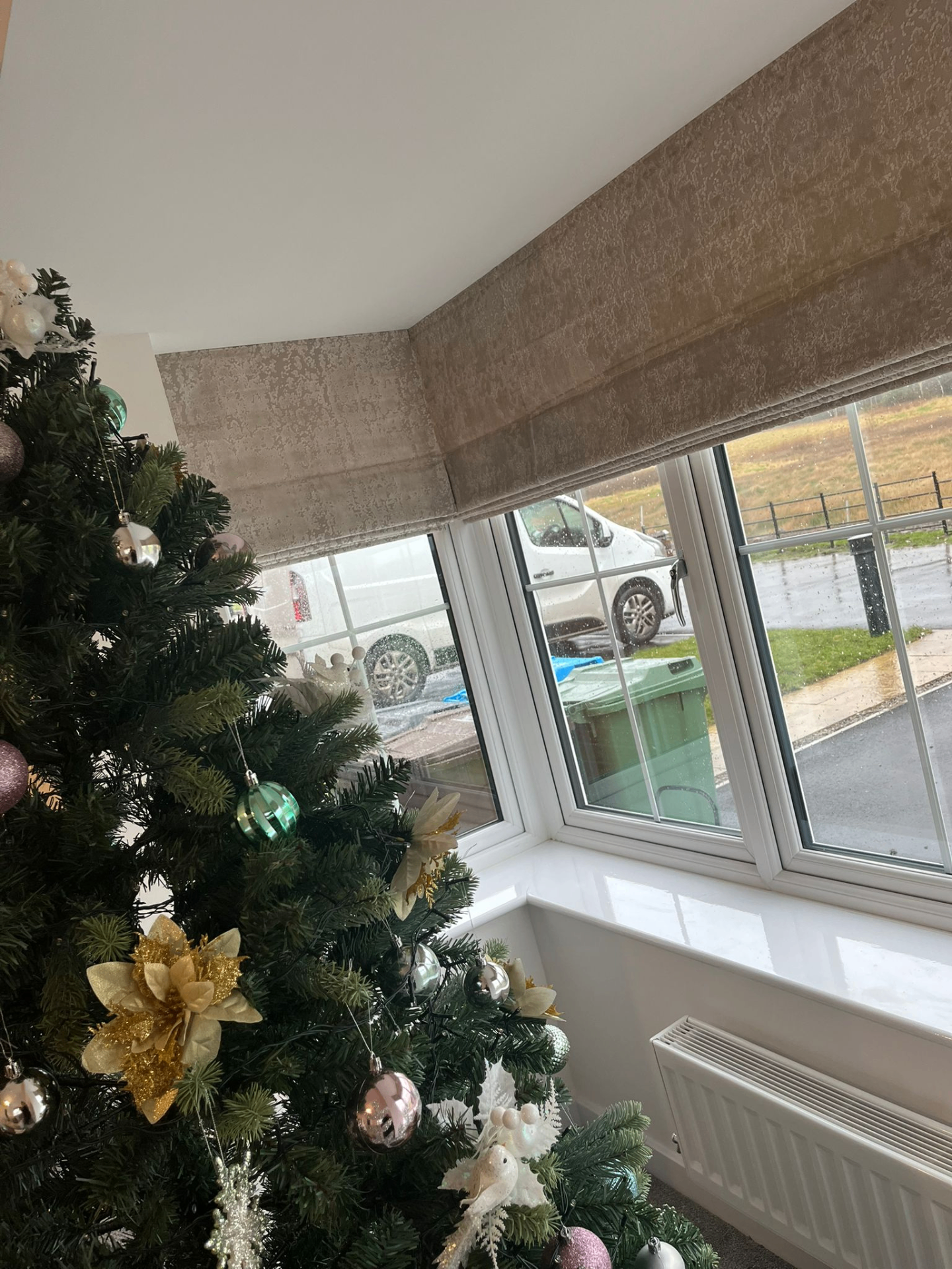 Close view of Roman blinds following the angle of a bay window