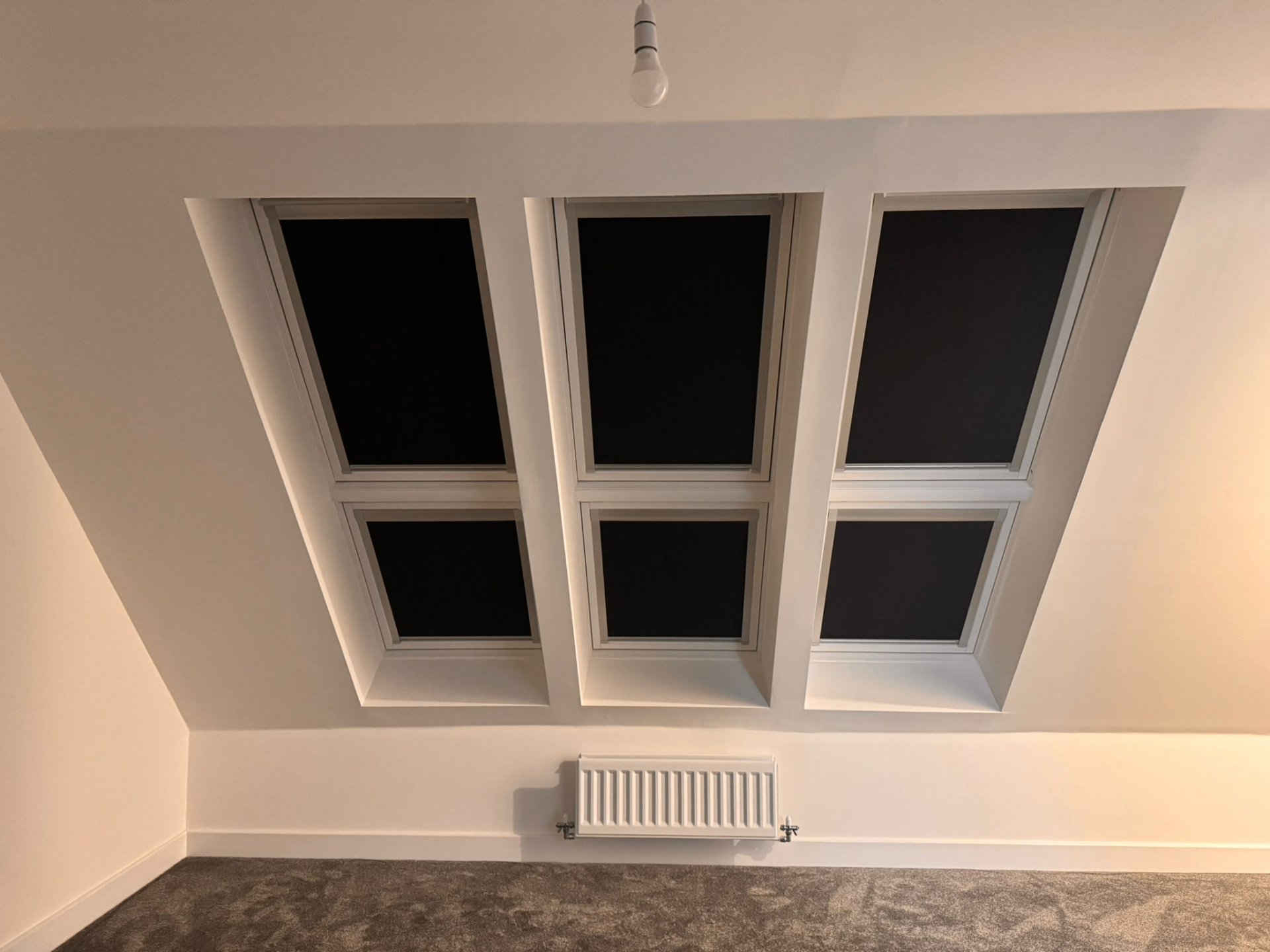 Three fitted Velux blackout blinds shown closed across loft roof windows