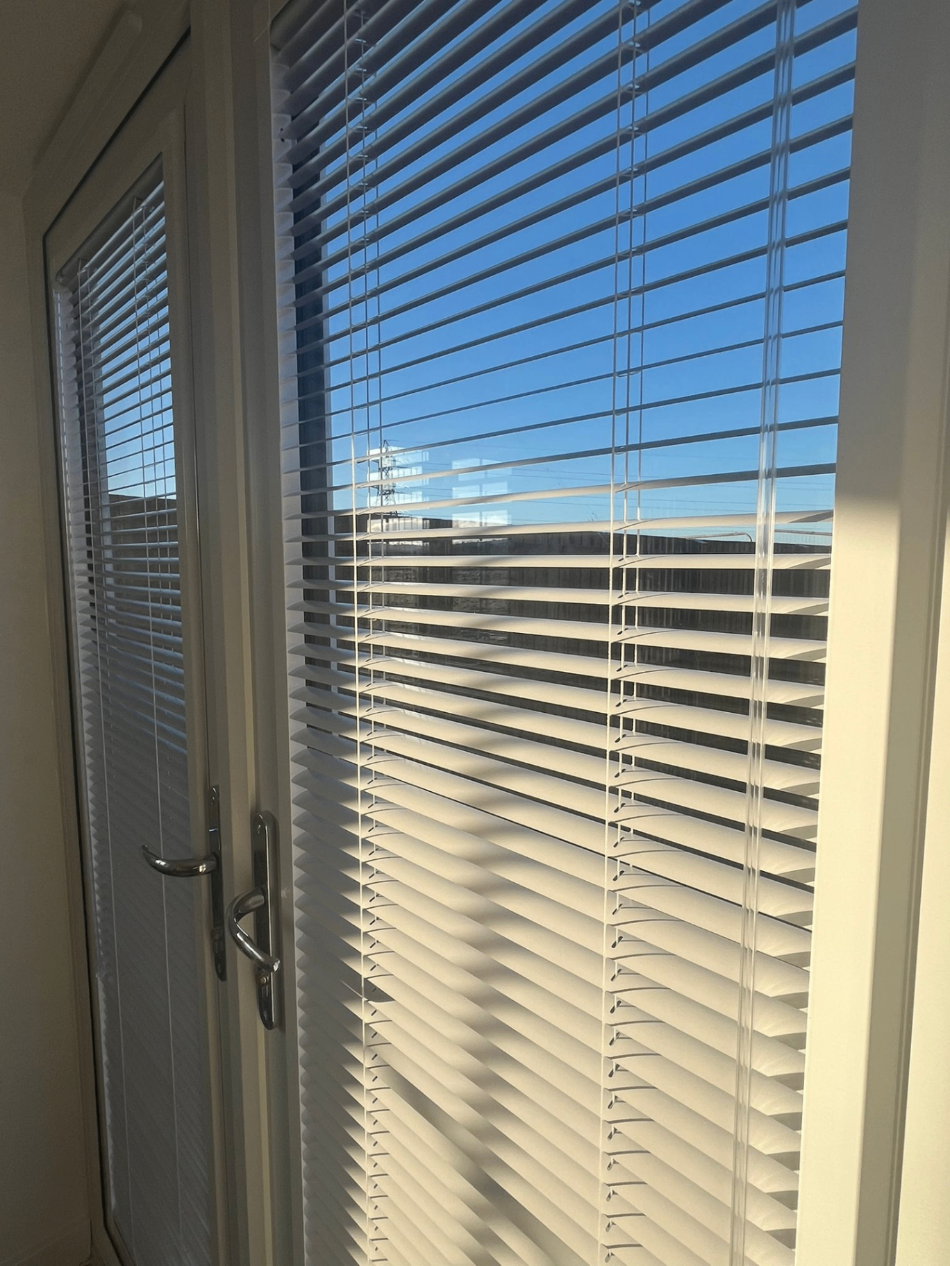 White Perfect Fit Venetian blinds fitted directly to glazed door panels