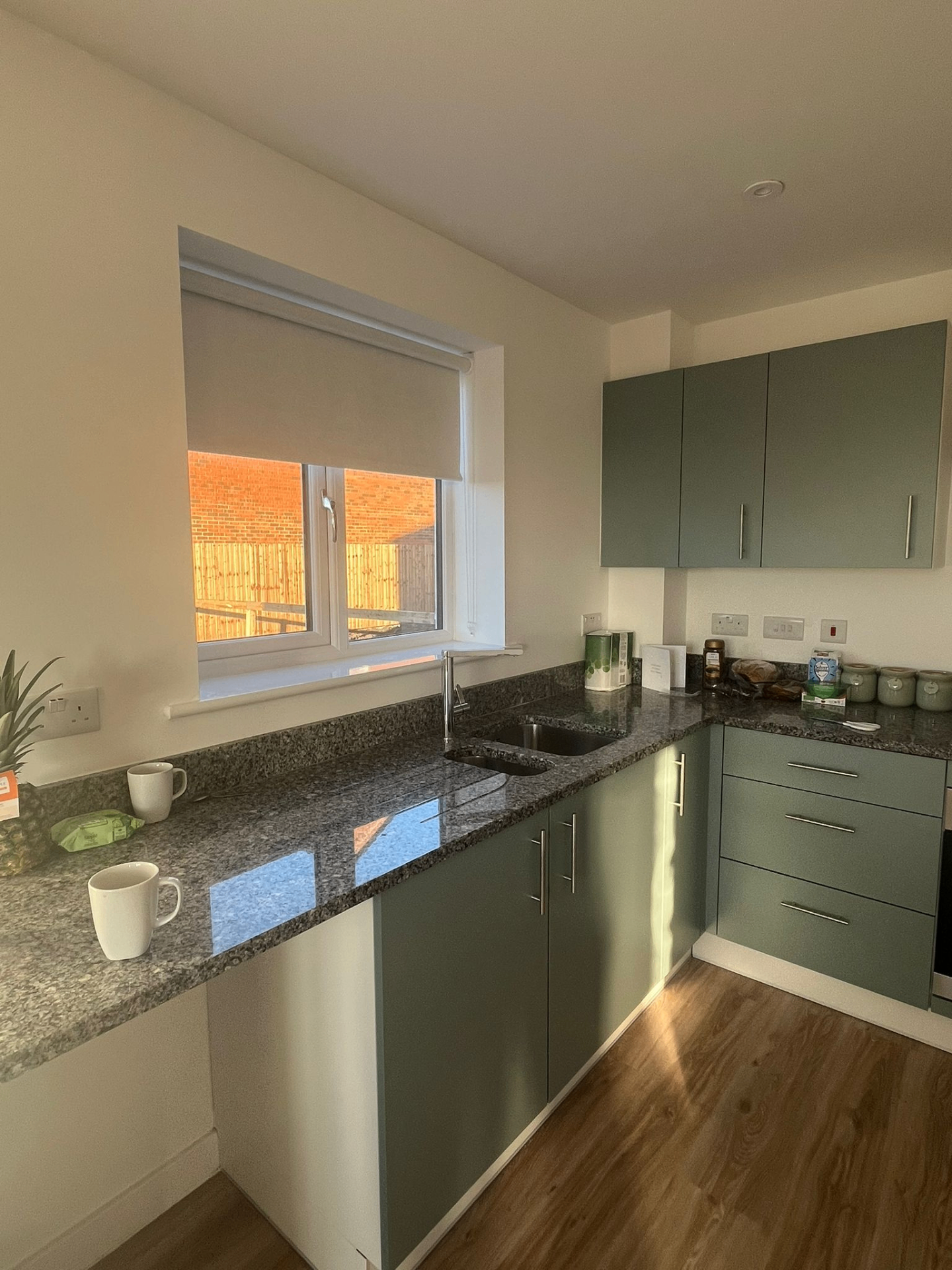 Soft grey roller blind fitted above a kitchen sink window