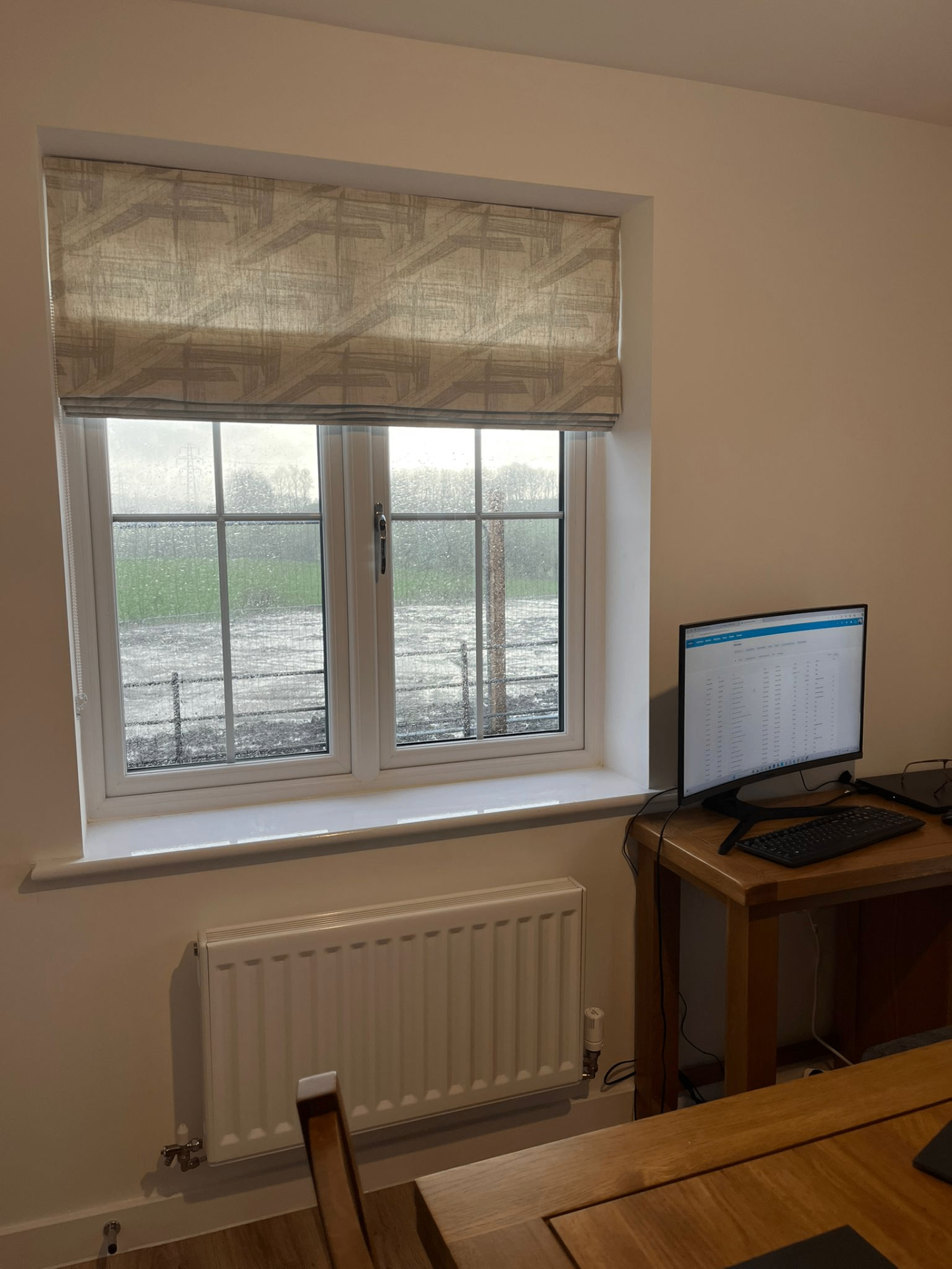 Patterned Roman blind fitted in a home office window